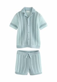 Chemise tricotée bleu clair à manches courtes avec boutons et short assorti, présentant un motif texturé et des poignets côtelés. Ceinture réglable.