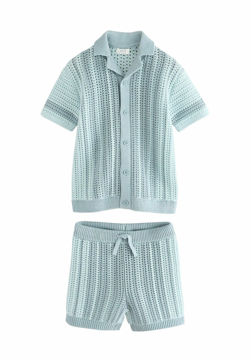 Chemise tricotée bleu clair à manches courtes avec boutons et short assorti, présentant un motif texturé et des poignets côtelés. Ceinture réglable.