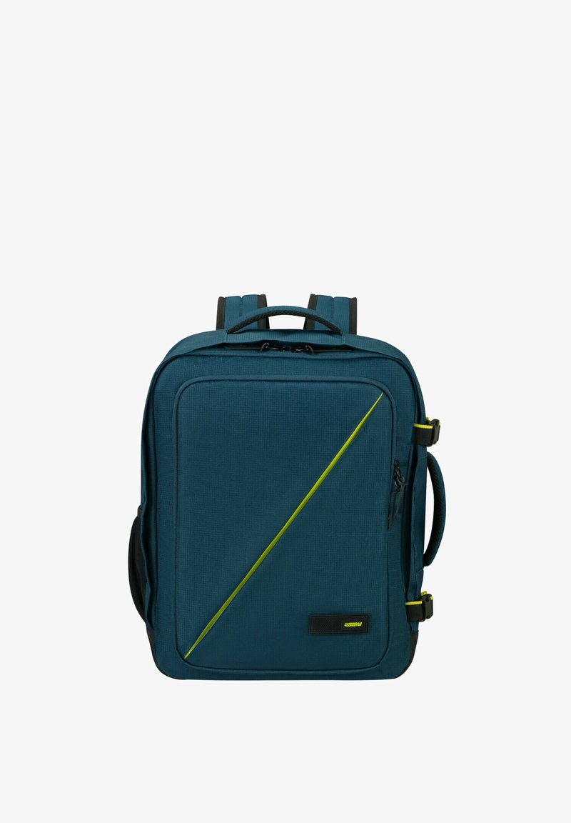 Zaino in tessuto turchese con design geometrico, caratterizzato da una striscia diagonale verde lime, manico superiore, spallacci regolabili e tasche laterali.