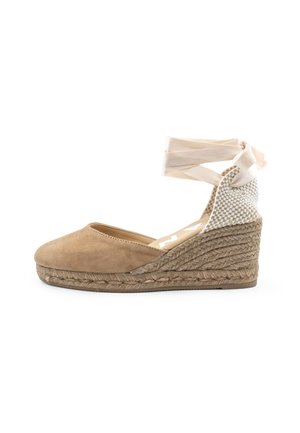 Beige Keil-Espadrille mit geschlossenem Zehenbereich, geflochtener Jutsohle, gewebter Fersenpartie und beigem Fußgelenkband.