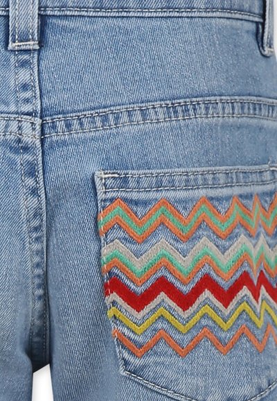 I pantaloni denim corti con un lavaggio leggero presentano una tasca posteriore decorata con ricami zigzag multicolori nei toni dell'arancione, del teal, del rosso e del giallo.