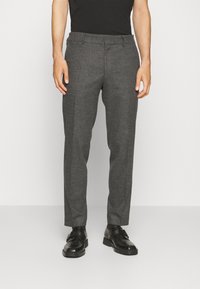 Grå texturerade byxor med rak passform, med flat front, bältesöglor och sidofickor, i kombination med svarta skor.