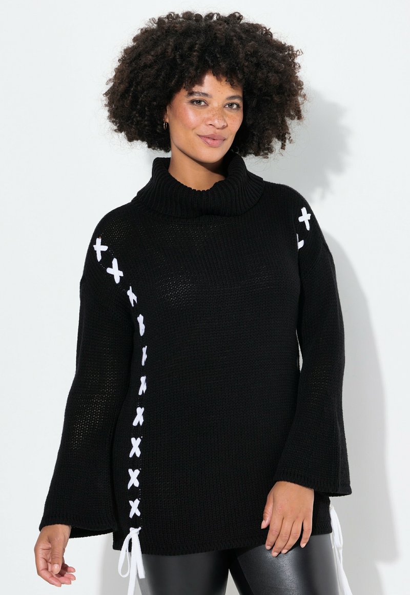 Schwarzer Strickpullover mit hohem Kragen, ausgestattet mit weißen X-Stich-Details entlang der Seite und Glockenärmeln. Weiche Textur, lässige Passform.