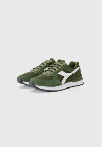 Green athletic shoes made of mesh and suede, featuring a white accent, round toe, padded collar, and textured rubber outsole.