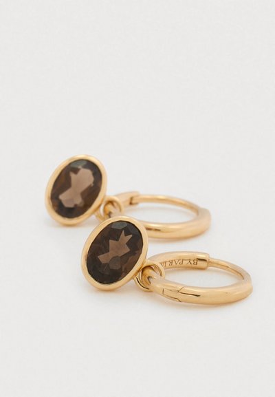 Cercei rotunzi din aur cu pietre prețioase ovale, maro. Pietrele sunt tăiate în fațete, iar montura este netedă, cu un finisaj lustruit.