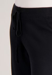 Zwarte sweatpants met een zachte textuur, verstelbare tailleband met koordjes en een rechte pijp. Ideaal voor casual gebruik en comfort.