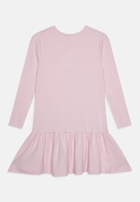 Langermet rosa kjole laget av ribbet stoff; har en utsvingt volangkant og rund hals. Glatt tekstur, enkelt design.