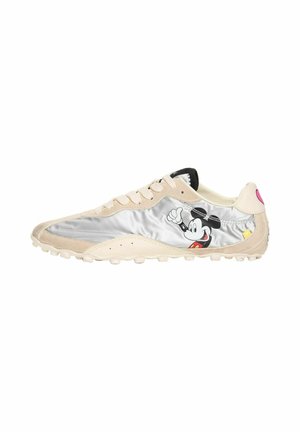 Zapatilla baja beige y plateada con diseño de cordones y un gráfico de Mickey Mouse sonriente en el lateral.