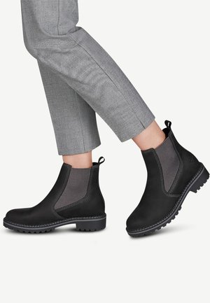 Bottines noires avec panneaux latéraux en mesh, semelle texturée et coutures contrastantes. Bout arrondi et languette pour un enfilage facile.