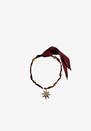 Collier ras-du-cou en tissu avec des perles vertes, ambrées et blanches, doté d'un pendentif doré en forme de soleil et attaché avec un ruban rouge foncé.