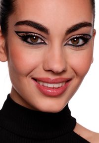 Primo piano di un volto che mostra un eyeliner alato scuro, sopracciglia ben definite e labbra naturali lucide. La pelle appare liscia e dal tono uniforme. Dolcevita nero.