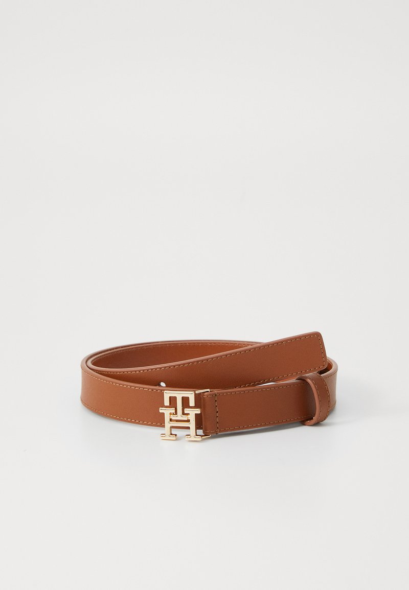 Cinto de pele castanha com uma textura suave, apresentando uma fivela dourada com iniciais entrelaçadas e bordas bem costuradas.