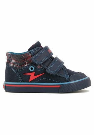 Zapatillas altas de color azul marino con diseño de rayo rojo, doble correa de Velcro, tela texturizada y suelas de goma. Acentuadas por un patrón de cuadros.
