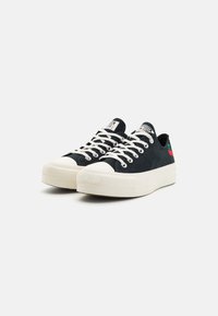 Sneaker nere in tela con suole in gomma bianca, punte rotonde e disegno ricamato di ciliegie rosse e verdi sul tallone. Lacci bianchi e etichetta sulla lingua.
