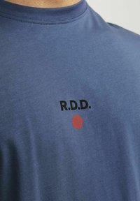 Tricou din bumbac albastru, cu guler rotund și un print grafic cu "R.D.D." în negru și un motiv de cerc roșu pe față.
