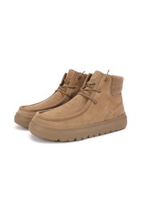 Botas de tobillo de ante en tono beige con un cuello suave y texturizado, punta redondeada y suela de goma. Presentan costuras sutiles y un diseño de cordones.