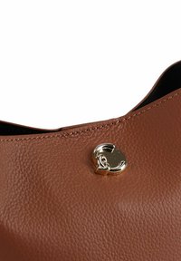 Bruine handtas van getextureerd leer met een gouden sluiting bovenop; verstevigde naden en een gladde binnenkant zichtbaar.