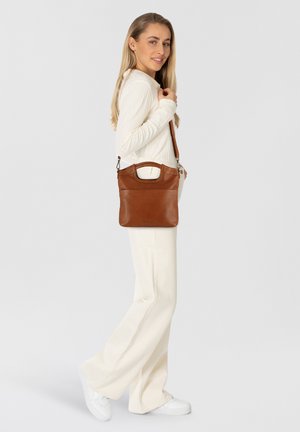 Borsa a tracolla in pelle marrone con manico superiore, tasca frontale e tracolla regolabile, caratterizzata da una texture liscia e un design minimalista.