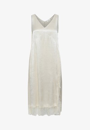 Világos bézs, ujj nélküli ruha selymes anyagból, V-nyakkivágással, finom textúrával és elegáns csipkeborítással a szegélyen.