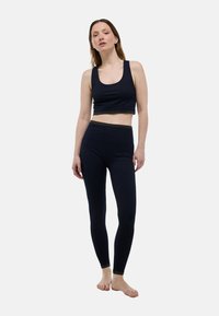 Haut court côtelé bleu marine avec des bretelles larges et un accent pailleté sur l'ourlet, associé à un legging taille haute assorti. Tissu doux et extensible.