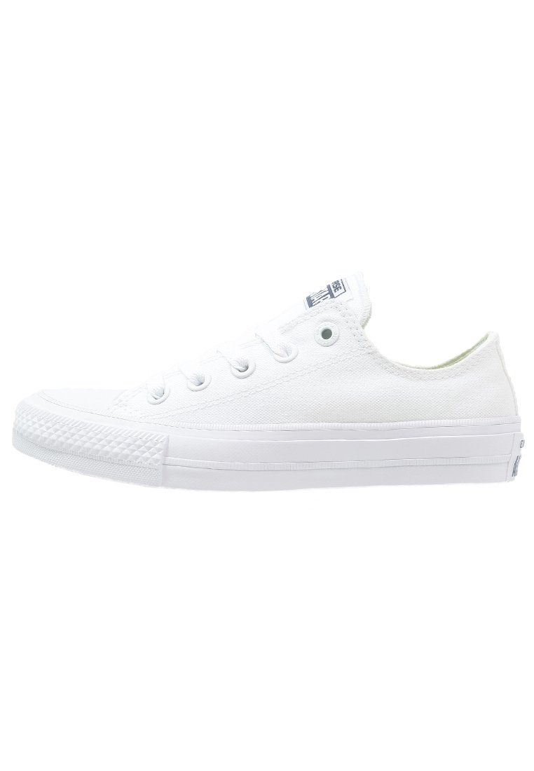 Zapatillas de lona blancas con cordones planos, puntera redonda, suela de goma y capuchón de punta texturizado. Incluye un pequeño logo en la lengua.