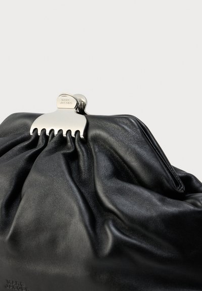 Μαύρο δερμάτινο τσαντάκι χειρός με σχεδιασμό μαζεμένο, διαθέτει ασημένιο κούμπωμα σε σχήμα χτένας. Λείο υλικό και ελάχιστη σήμανση бренδας.