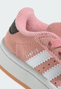 Ružové semišové tenisky s bielymi koženými pruhmi, textúrovanou gumovou podrážkou a čiernym akcentom na pätke. Logo "CAMPUS" na boku.