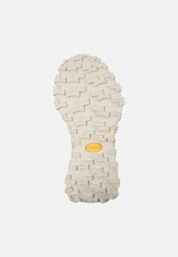 Suola Vibram di colore crema con un motivo di battistrada testurizzato e multidirezionale e un dettaglio del logo giallo al centro.