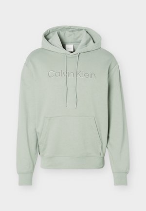 Sweat à capuche Calvin Klein vert clair avec poche avant kangourou, capuche à cordon de serrage réglable et logo brodé sur la poitrine.