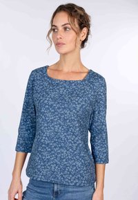 Bluse mit langen Ärmeln in Blau mit quadratischem Ausschnitt und lässiger Passform. Der Stoff zeigt kleine weiße Blumenmuster.