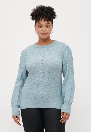 Light blue knitted sweater with a wavy pattern, ribbed cuffs, and crew neckline, featuring textured fabric and a relaxed fit.