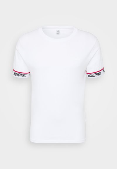 Balts kokvilnas T-krekls ar īsām piedurknēm, ar melnu un sarkanu "MOSCHINO" zīmolu uz piedurknēm un minimālistisku dizainu.