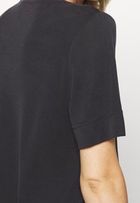 T-shirt med kort ärm i marinblått med rund halsringning, mjuk tygkvalitet och synliga söm detaljer på ärmarna.