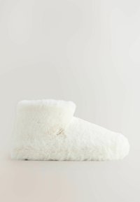 Valge karvane sussikreen pehme plush-tekstiiliga ja keskmise pahkluku kõrgusega, nähtav külgprofilis lihtsal taustal.