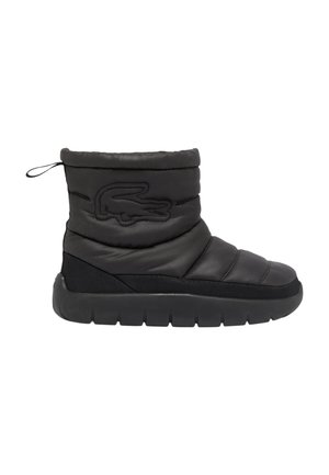 Bota estilo puffer negra con textura acolchada, suela de goma y un logo bordado prominente. Cuenta con una lengüeta para facilitar su uso.