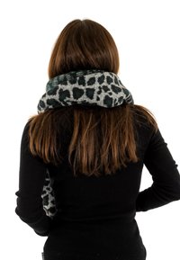 Bufanda de leopardo gris y verde hecha de tela suave, envuelta alrededor del cuello; combinada con una camiseta de manga larga negra de canalé.