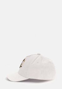 Cappello in cotone bianco con visiera curvata, caratterizzato da un design grafico sulla parte anteriore e fori per la ventilazione. Texture morbida con corona arrotondata.