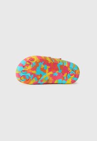Bunte Schuhsohle mit einem wellenförmigen, strukturierten Muster in lebhaftem Pink, Gelb und Blau, mit erhöhten runden Griffen für bessere Traktion.
