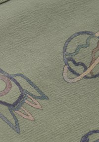 Olivgrön tyg med ett mönster av raketer och planeter i olika färger, med detaljerade konturer och slät textur.