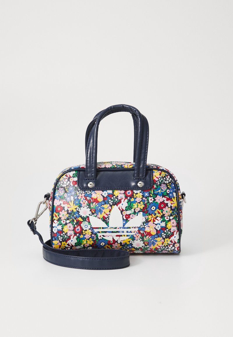 Bolso con estampado floral, base de piel sintética azul oscuro, doble asa, correa ajustable y detalle de logo blanco en la parte delantera.