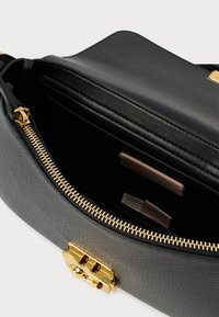 Grijze leren handtas met een getextureerd oppervlak, gouden accenten, een bovenrits en een ruime, donkere binnenkant met een merkembleem.