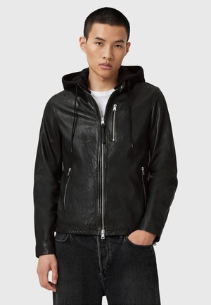 Veste en cuir noir avec capuche, dotée de poches avant zippées, de cordons réglables et d'une finition lisse.