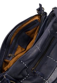 Leren handtas met een donkerblauwe buitenkant, lichtbruine stoffen voering, meerdere ritszakken en decoratieve stikseldetails.