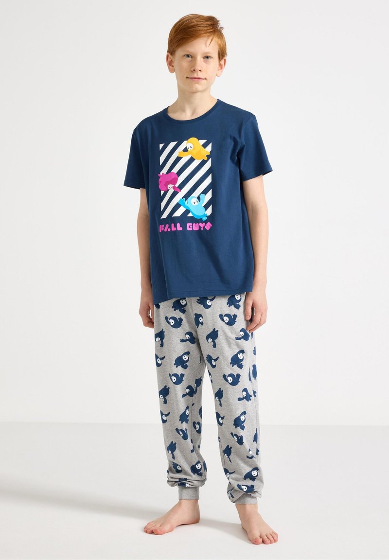 Μπλε βαμβακερό μπλουζάκι με πολύχρωμους κινούμενους χαρακτήρες και λευκές ρίγες· γκρι παντελόνι με σχέδια από μπλε ψάρια· άνετη εφαρμογή, casual σχεδιασμός.