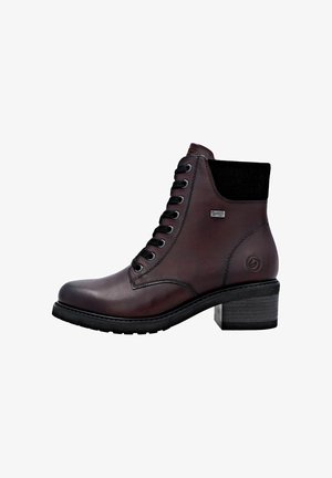 Bottine en cuir marron avec panneau élastique noir, design à lacets, couture renforcée, talon géométrique et semelle noire texturée.