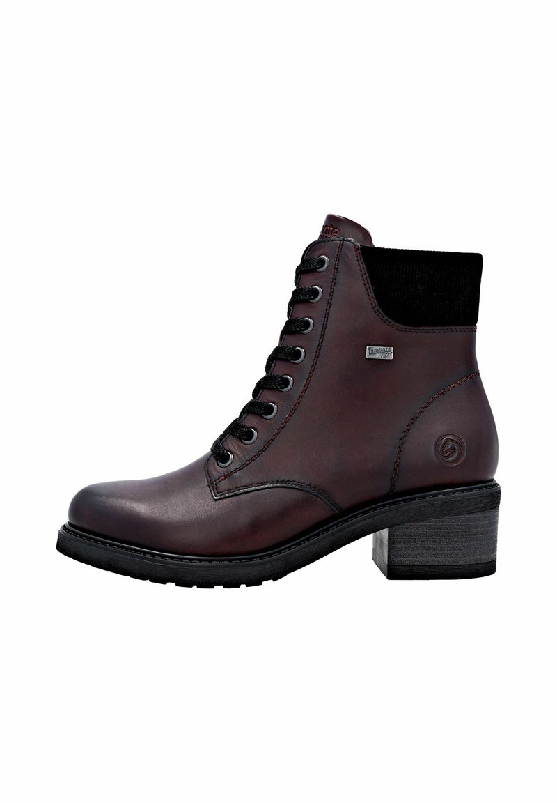 Bota de tobillo de cuero marrón con panel elástico negro, diseño con cordones, costuras reforzadas, tacón geométrico y suela texturada negra.