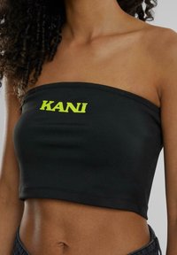Musthave musta rihmatu crop top, millel on roheline "KANI" logo, valmistatud siledast materjalist, millel on keha mugavalt järgnev disain ja puhas õmblusdetailid.
