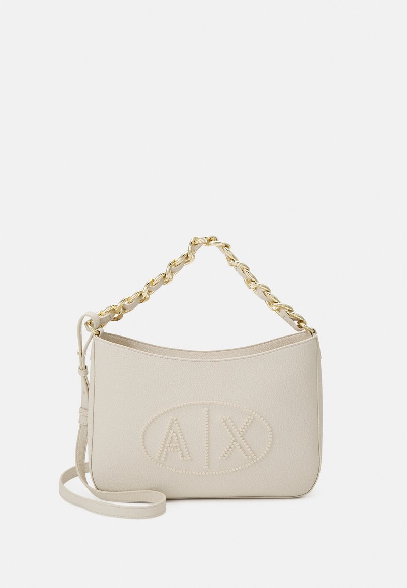 Borsa a mano in pelle beige con forma curvata, manico a catena dorata, logo "A/X" impresso e tracolla regolabile. Texture liscia.