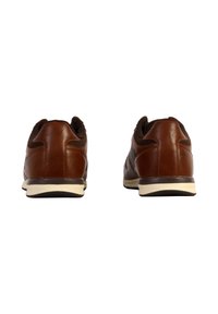 Zapatillas de cuero marrón con un acabado suave, texturas oscuras contrastantes y una suela de goma blanca. Presenta un collar y una parte trasera acolchados.