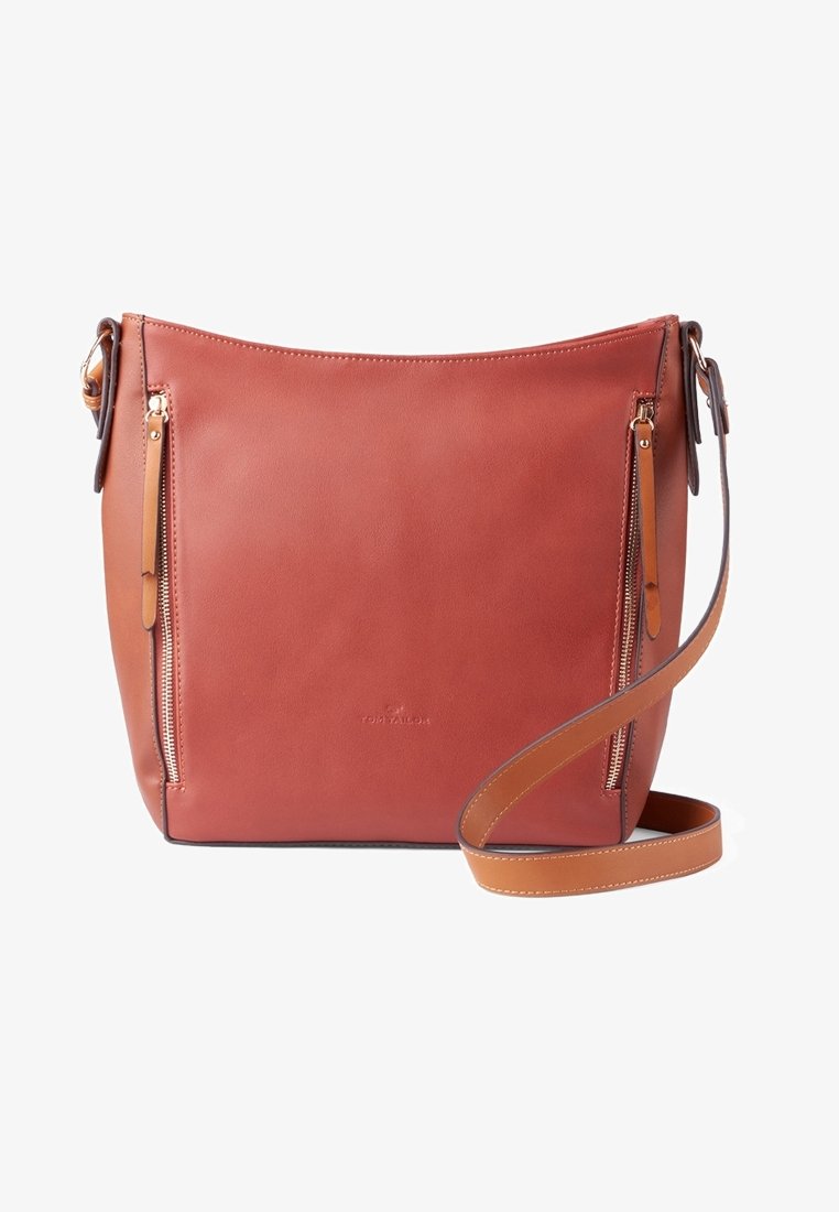 Bolso de cuero marrón con una textura suave, que cuenta con bolsillos con cierre en la parte delantera, una correa ajustable y un diseño minimalista.